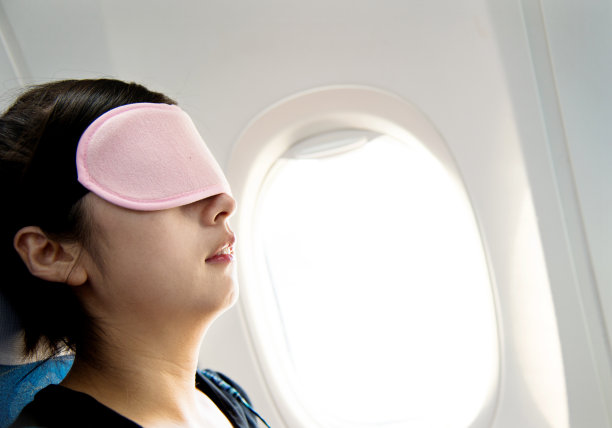 年轻女子在飞机上打盹图片下载