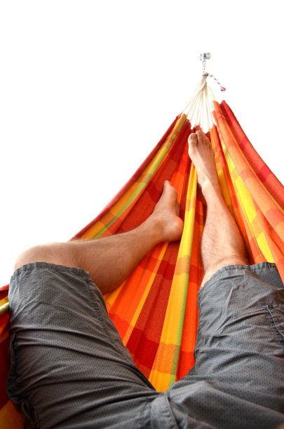 男人的腿躺在明亮的吊床上，孤立在白色的背景上图片下载