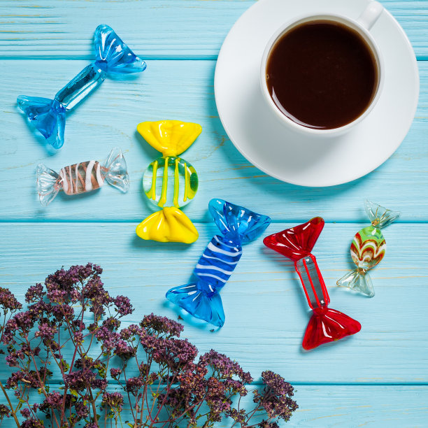 平躺着，蓝色的木头背景上放着一杯咖啡和糖果图片下载