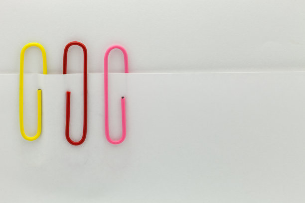 彩色回形针在白纸背景上。图片下载