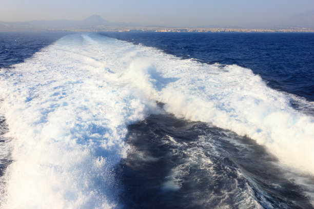 飞溅的水花和水在一艘高速船后面喷射图片下载