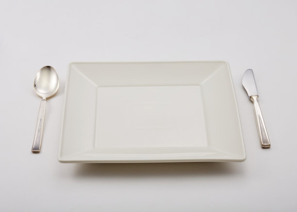 空盘子和刀叉工具，放在一张白色的桌子上图片下载