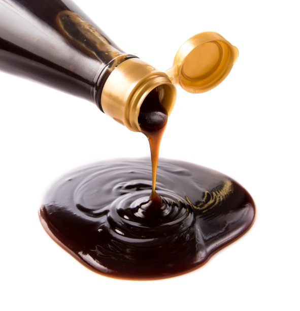 蚝油从瓶子里倒出来，背景是白色的图片下载