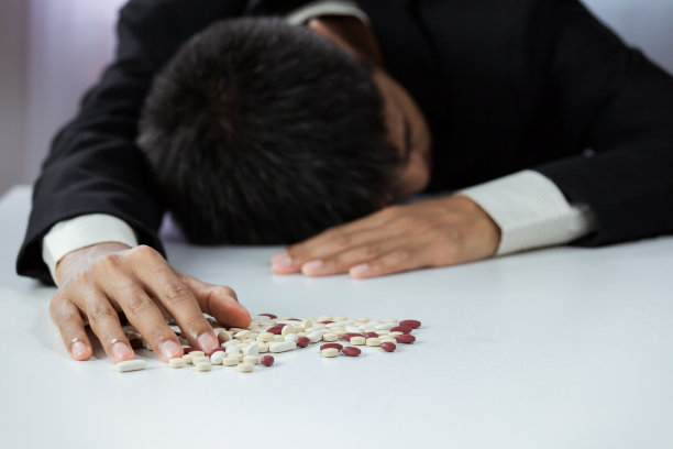 近距离的手商人与药丸在办公桌上的工作空间。失效工作概念图片下载