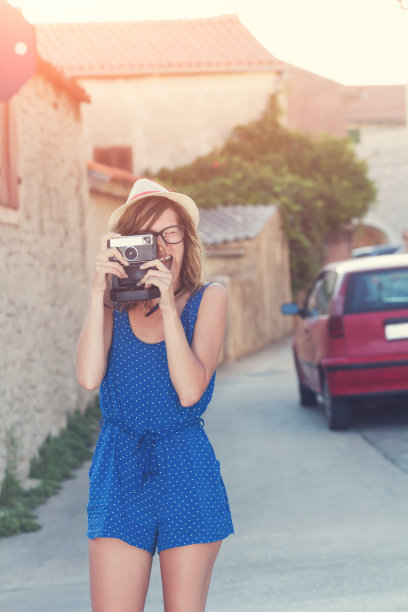 可爱的年轻女性拿着复古相机。图片下载