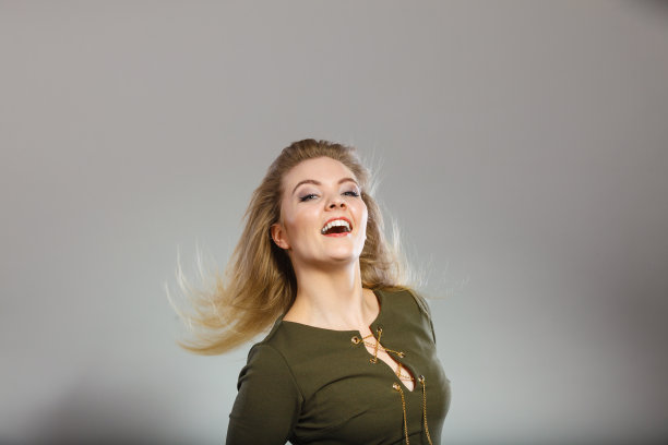 迷人的金发女人穿着紧身的绿色卡其色上衣图片下载