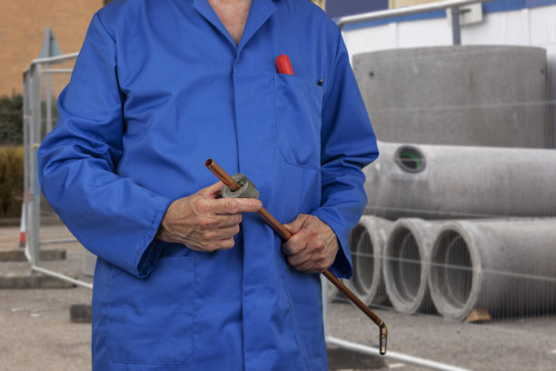 建筑工地的管道工正在切割一根铜管图片下载