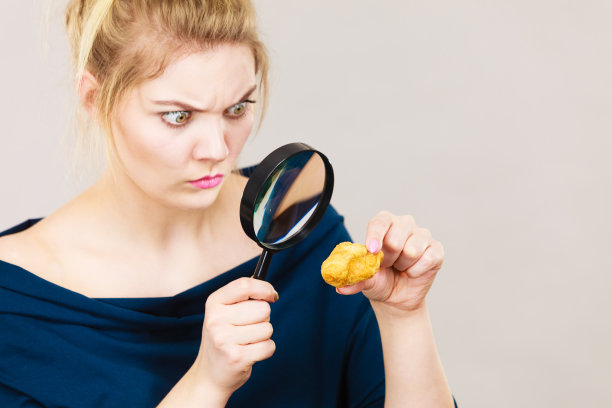 拿着放大镜审视面包的女人图片下载