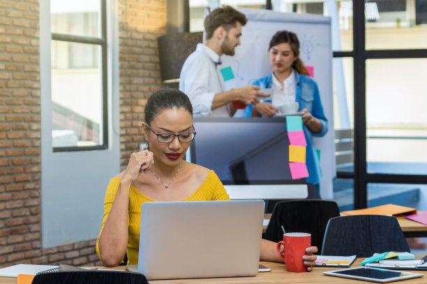 商业女性的肖像工作与电脑上的照片模糊的亚洲和多民族商务人士与休闲西装在现代办公室，人的商业集团的概念图片下载