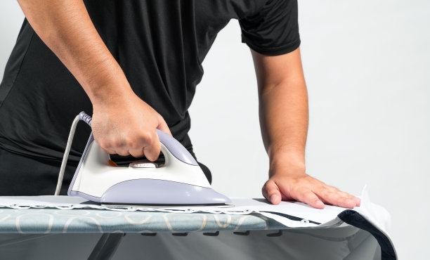 男人在桌子上熨衬衫，做家务，复印空间。图片下载