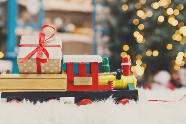 玩具火车开着圣诞礼物上雪花，假日背景图片下载