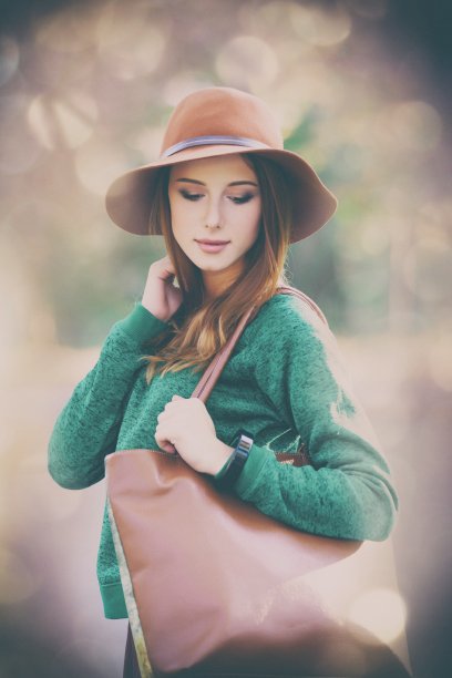 女人站在美丽的秋天公园里图片下载