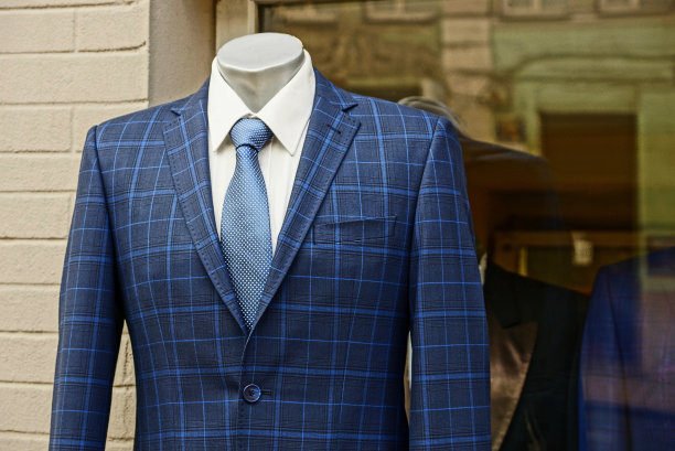 穿着西装的人体模特站在街边的一个商店橱窗和一堵砖墙旁边图片下载