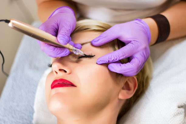 专业美容师在美容工作室应用永久化妆眼线纹身素材图片