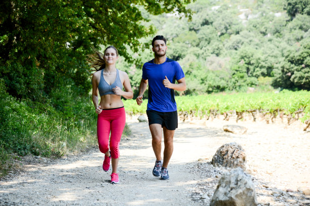 美丽的年轻夫妇一起在户外乡村森林里跑步运动健身锻炼图片下载