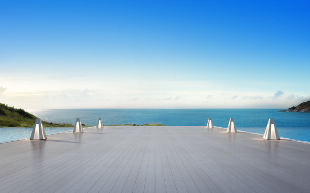 海景游泳池和空旷的大露台在现代豪华海滩别墅与蓝天背景，灯在度假屋或酒店的大型木制甲板上图片下载
