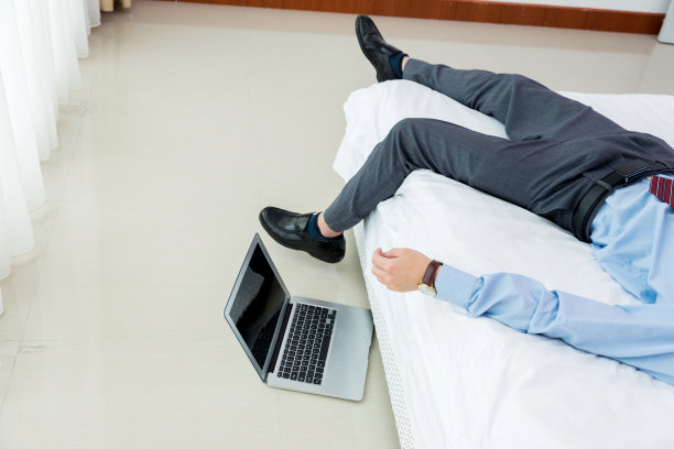 疲惫的商人躺在旅馆的床上图片下载