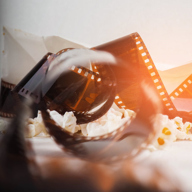 影片在螺旋中，靠近爆米花，复制空间为文字，时尚亮点在照片中，概念，电影产业，电影，抽象构成电影，在白色的背景上图片下载