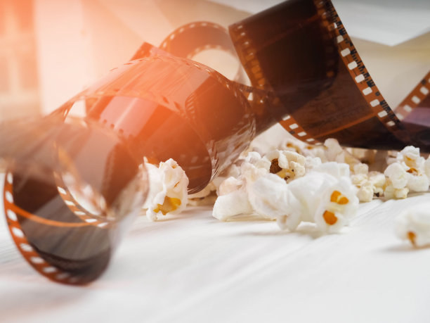 影片在螺旋中，靠近爆米花，复制空间为文字，时尚亮点在照片中，概念，电影产业，电影，抽象构成电影，在白色的背景上图片下载