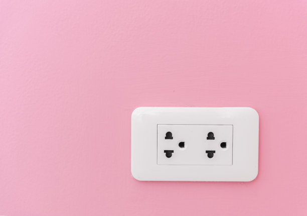 粉色墙壁上的电源插头图片下载