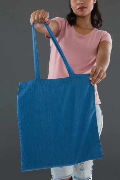 拿着蓝色购物袋的年轻女子中部图片下载