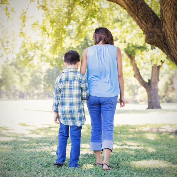 妈妈和儿子在公园里散步的后视图图片下载