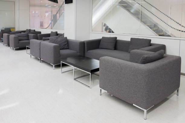 深灰色的布质沙发在候车室或现代办公室内带有休息区，工作场所。空的房间。图片下载