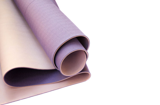 练习瑜伽或普拉提的配件。卷丁香运动垫在白色的背景。孤立的形象。积极的生活方式，运动理念。图片下载