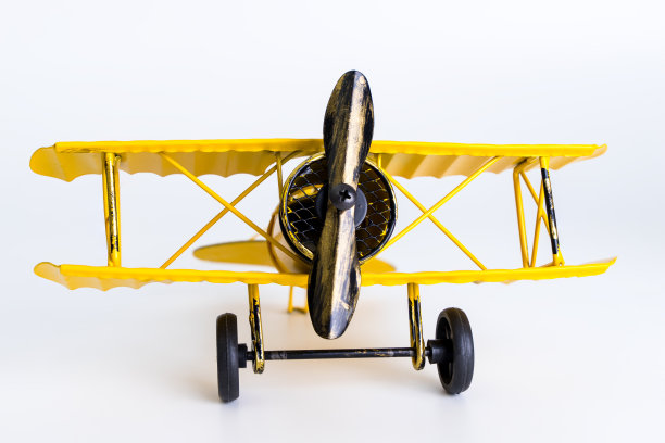 老式的黄色金属玩具飞机上的白色背景图片下载