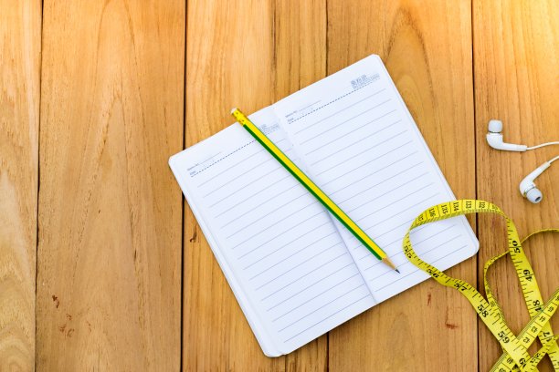 记事本与铅笔在木板和树模糊的背景。使用壁纸或背景教育，商业照片。注意产品的纸张和概念或复制空间和注意。图片下载