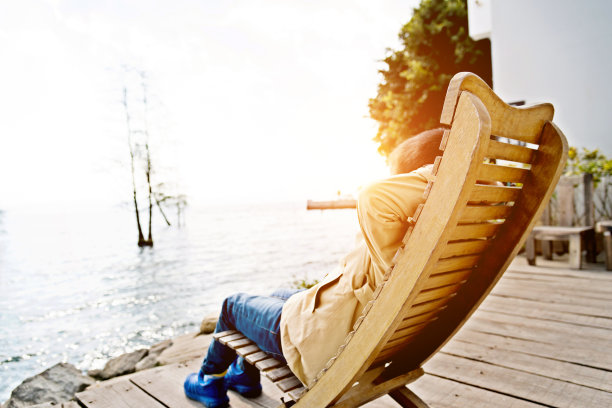 小男孩在湖边的椅子上休息图片下载