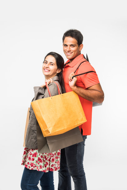 印度快乐和年轻夫妇购物袋，亚洲男人和女人拿着购物袋，孤立在白色的背景图片下载