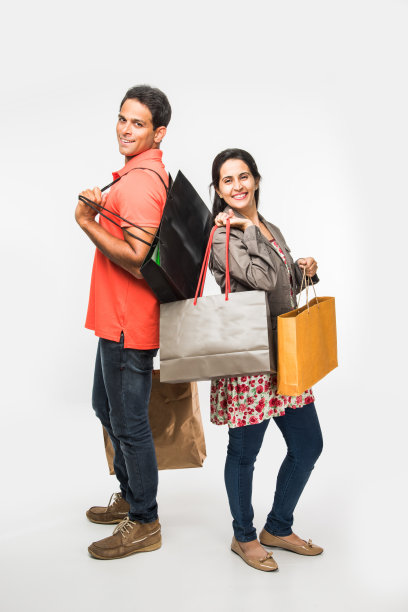 印度快乐和年轻夫妇购物袋，亚洲男人和女人拿着购物袋，孤立在白色的背景图片下载