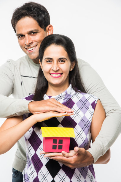印度聪明和快乐的夫妇持有3D纸房子模型和钥匙，孤立地站在白色背景，亚洲夫妇和房地产概念的库存照片图片下载