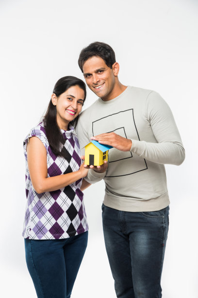 印度聪明和快乐的夫妇持有3D纸房子模型和钥匙，孤立地站在白色背景，亚洲夫妇和房地产概念的库存照片图片下载