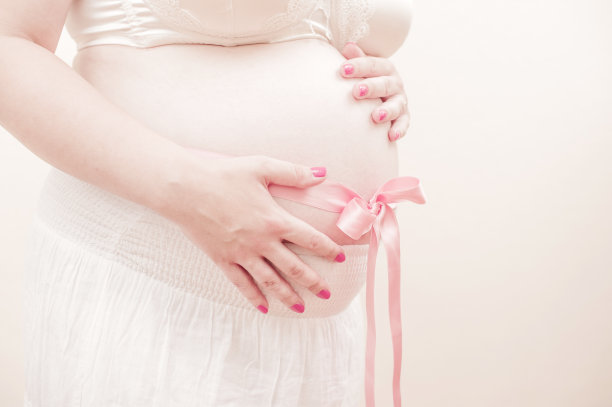 系着粉色丝带的孕妇肚子图片下载