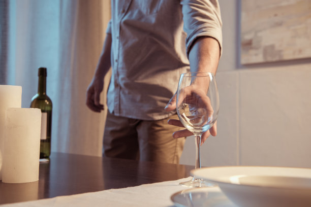 男人为浪漫的晚餐端上酒杯的照片图片下载