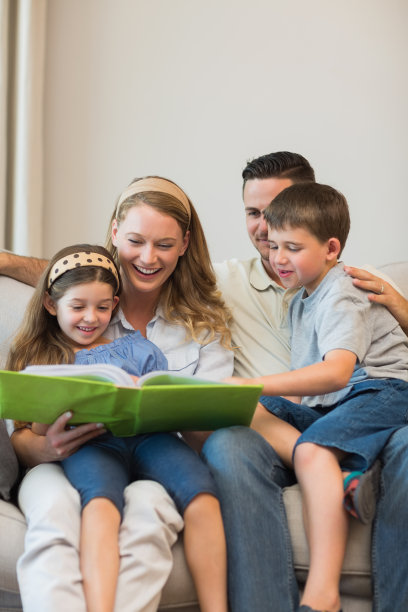 一家人坐在家里的沙发上看相册图片下载