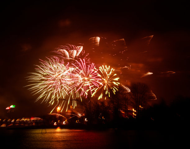 抽象的，模糊的，虚掩风格的彩色烟花照片在一个红色的基调之上的河流图片下载