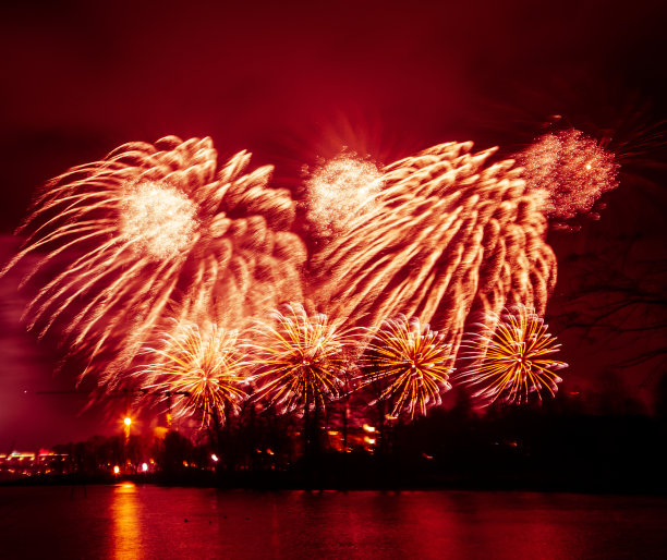 抽象的，模糊的，虚掩风格的彩色烟花照片在一个红色的基调之上的河流图片下载