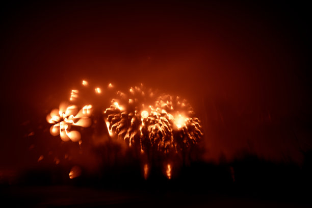 抽象的，模糊的，虚掩风格的彩色烟花照片在一个红色的基调之上的河流图片下载