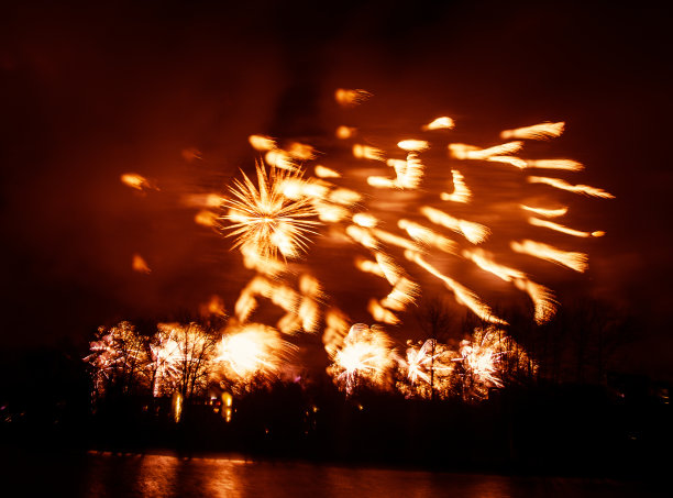 抽象的，模糊的，虚掩风格的彩色烟花照片在一个红色的基调之上的河流图片下载