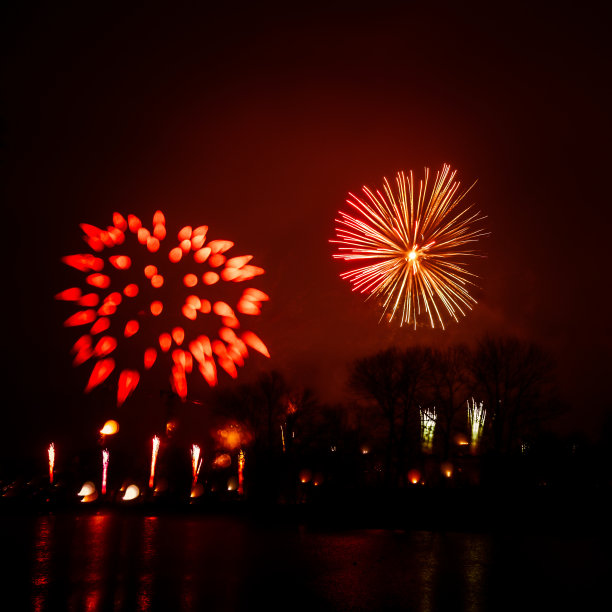抽象的，模糊的，虚掩风格的彩色烟花照片在一个红色的基调之上的河流图片下载