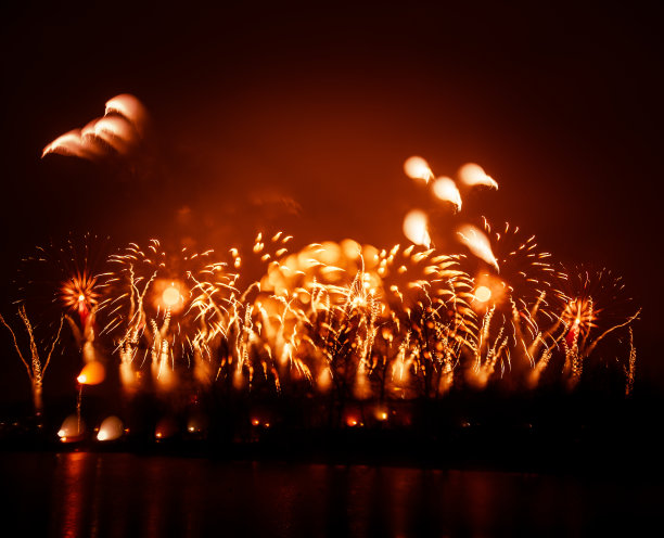 抽象的，模糊的，虚掩风格的彩色烟花照片在一个红色的基调之上的河流图片下载