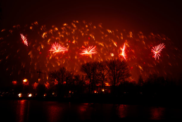 抽象的，模糊的，虚掩风格的彩色烟花照片在一个红色的基调之上的河流图片下载