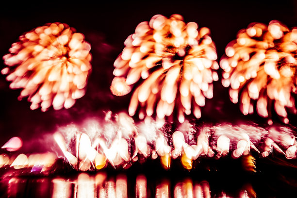 抽象的，模糊的，虚掩风格的彩色烟花照片在一个红色的基调之上的河流图片下载