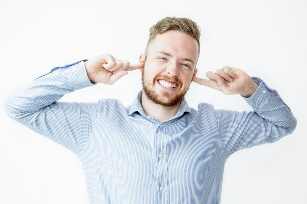 一名男子笑着用手指捂住耳朵图片下载