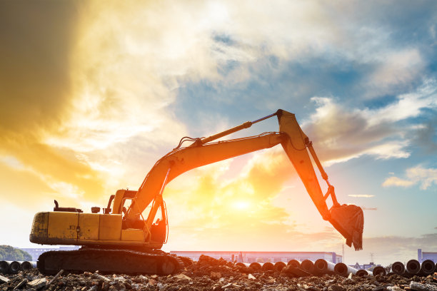 日落时分，挖掘机在建筑工地工作图片下载