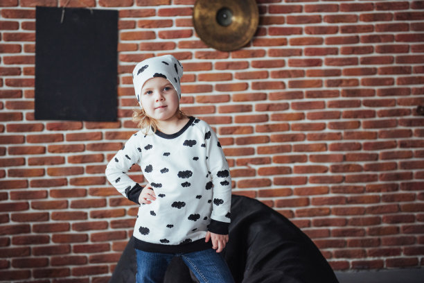 孩子穿着柔软温暖的睡衣在床上玩耍图片下载