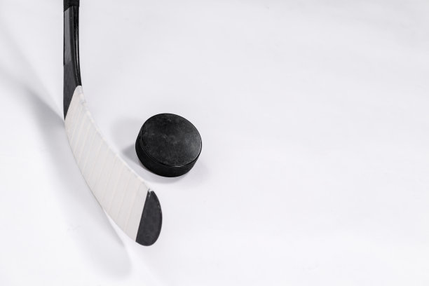 冰球和曲棍球棒在孤立的白色背景，复制空间。图片下载